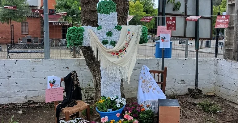 Vecinos celebrando el Día de la Cruz en Trassierra entre flores y música.