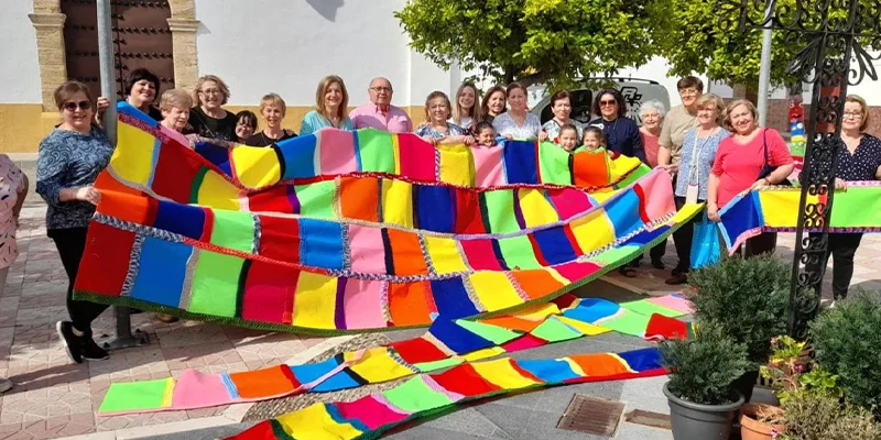 Vecinas y vecinos de Santa Cruz decorando el barrio con trabajos de punto y croché.
