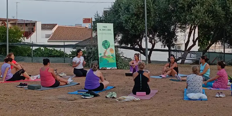 Personas practicando yoga al atardecer en la Plaza de los Olivos de Santa Cruz, Córdoba